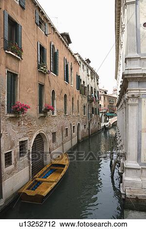 Stock Image - Canal with boat and buildings in Venice, Italy.. Fotosearch