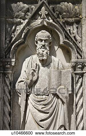 Stock Image - Relief sculpture of bearded male figure standing with book and holding up two fingers.. Fotosearch