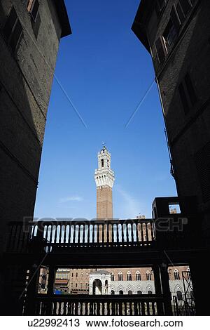 Torre del Mangia tower framed by buildings in alley. View Large Photo Image Stock Image - Torre del Mangia tower framed by buildings in alley.. Fotosearch