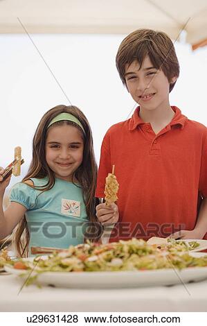 Stock Photo - Boy and girl at buffet. Fotosearch