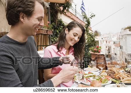 Couple at a table with Greek food View Large Photo Image Stock Image - Couple at a table with Greek food. Fotosearch