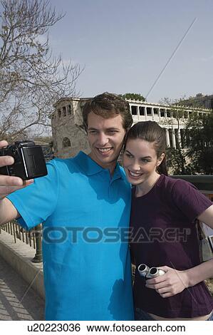 Couple at archaeological site photographing themselves View Large Photo Image Stock Photograph - Couple at archaeological site photographing themselves. Fotosearch
