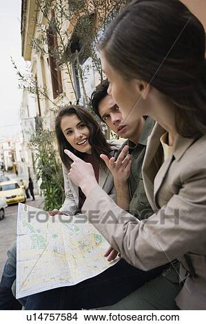 Man and two women reading map View Large Photo Image Picture - Man and two women reading map. Fotosearch