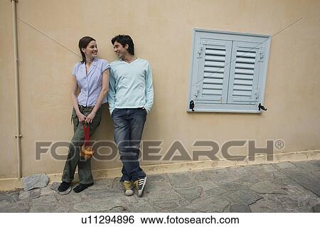 Stock Photograph - Man and woman at a wall with a picnic lunch. Fotosearch