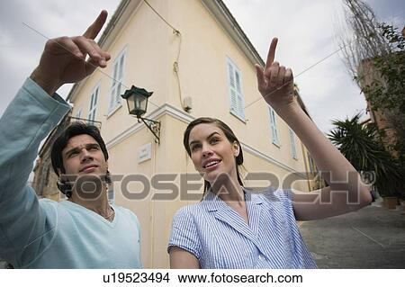 Picture - Man and woman pointing. Fotosearch