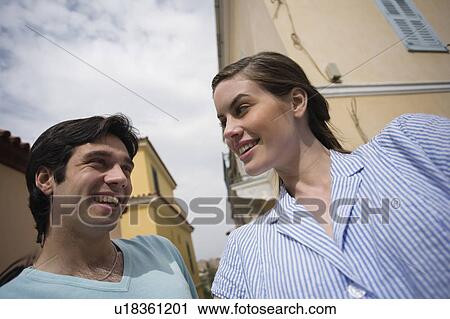 Stock Image - Man and woman smiling at each other. Fotosearch
