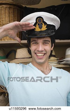Man trying on naval hat, saluting View Large Photo Image Stock Photograph - Man trying on naval hat, saluting. Fotosearch