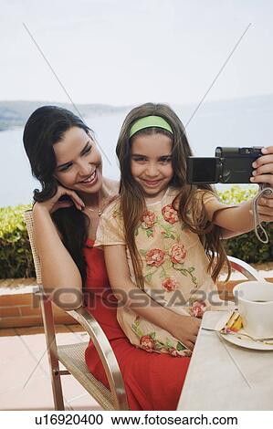 Mother and daughter at seaside cafe with camera View Large Photo Image Stock Image - Mother and daughter at seaside cafe with camera. Fotosearch