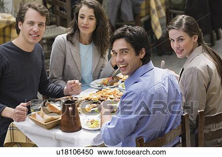 Two couples at a restaurant table View Large Photo Image Stock Image - Two couples at a restaurant table. Fotosearch