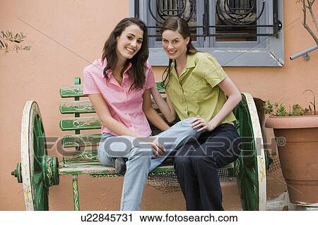 Two women on a bench posing View Large Photo Image Stock Image - Two women on a bench posing. Fotosearch