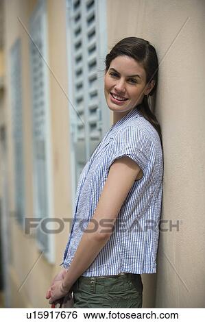 Stock Photograph - Woman leaning against a wall. Fotosearch