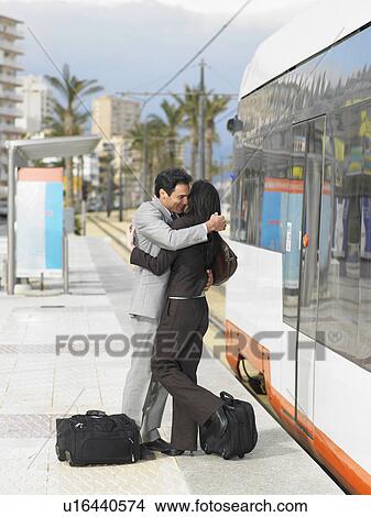 Businessman and businesswoman embracing by tram View Large Photo Image Picture - Businessman and businesswoman embracing by tram. Fotosearch
