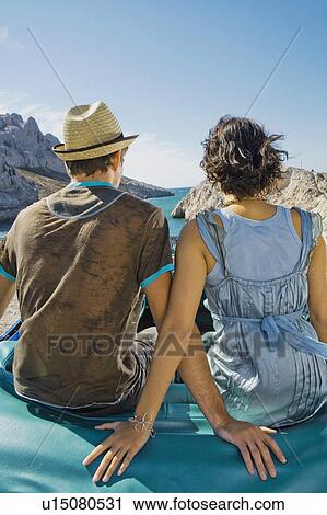 Man and woman sitting on car. View Large Photo Image Stock Image - Man and woman sitting on car.. Fotosearch