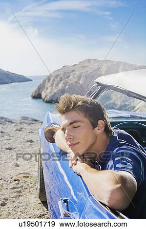 Stock Photo - Man in car leaning out window.. Fotosearch