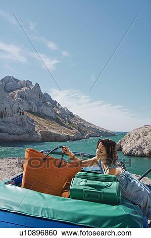 Woman lifting bag from car. View Large Photo Image Stock Image - Woman lifting bag from car.. Fotosearch