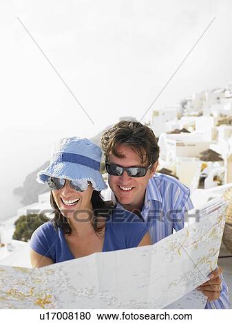 Stock Image - Couple looking at a map, laughing. Fotosearch