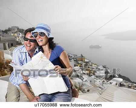 Couple looking at a map, laughing View Large Photo Image Stock Photo - Couple looking at a map, laughing. Fotosearch