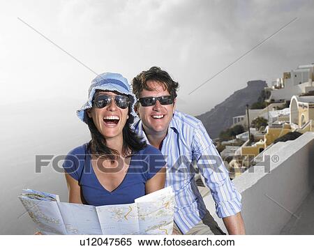 Couple looking at a map, laughing View Large Photo Image Stock Photography - Couple looking at a map, laughing. Fotosearch