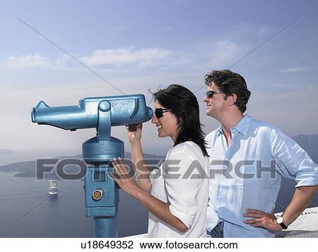 Stock Image - Couple looking through spyglasses. Fotosearch