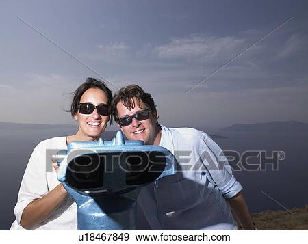 Couple looking through spyglasses View Large Photo Image Stock Photo - Couple looking through spyglasses. Fotosearch
