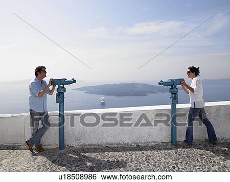 Stock Photograph - Couple looking through spyglasses. Fotosearch
