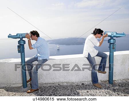Stock Photography - Couple looking through spyglasses. Fotosearch