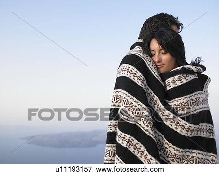 Couple wrapped in a cover, hugging View Large Photo Image Stock Photo - Couple wrapped in a cover, hugging. Fotosearch
