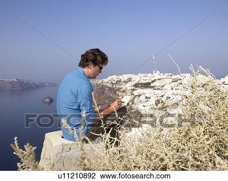 Stock Image - Man drawing in sketchbook. Fotosearch
