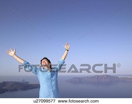 Stock Photo - Man stretching his arms, sea view. Fotosearch