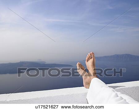 Men's feet on a low wall, sea view View Large Photo Image Stock Photo - Men's feet on a low wall, sea view. Fotosearch