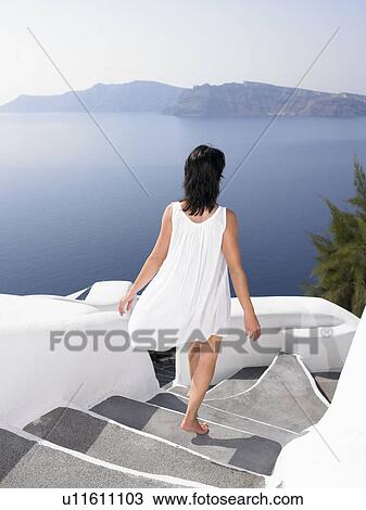 Stock Image - Woman climbing down the stairs. Fotosearch