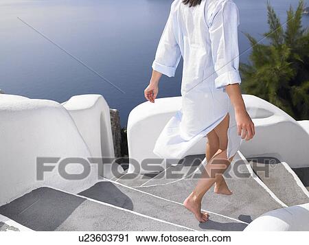 Stock Image - Woman climbing down the stairs. Fotosearch
