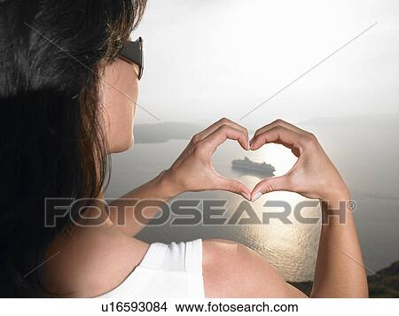Woman framing a boat with her hands View Large Photo Image Picture - Woman framing a boat with her hands. Fotosearch