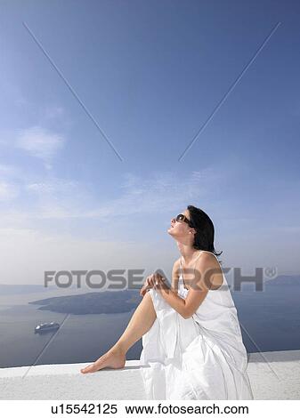 Stock Photography - Woman resting on a white wall. Fotosearch