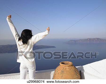 Woman stretching her arms, sea view View Large Photo Image Picture - Woman stretching her arms, sea view. Fotosearch