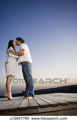 Stock Photo - Couple kissing on a dock.. Fotosearch