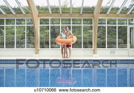 Couple standing in rubber ring by pool. View Large Photo Image Stock Photograph - Couple standing in rubber ring by pool.. Fotosearch