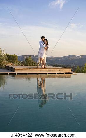 Stock Image - Loving couple embracing on wood dock in nature.. Fotosearch