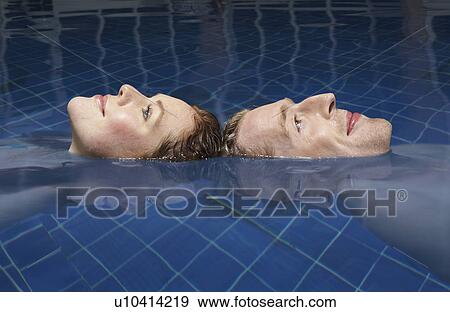 Man and woman floating in a pool. View Large Photo Image Stock Photo - Man and woman floating in a pool.. Fotosearch