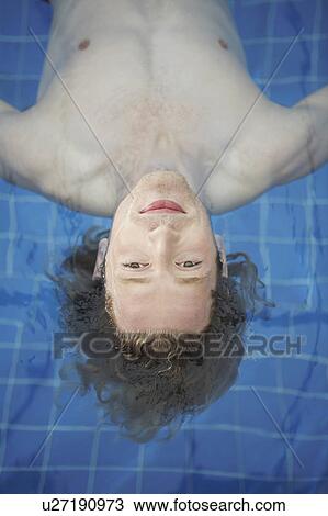 Portrait of a man floating in a pool. View Large Photo Image Stock Image - Portrait of a man floating in a pool.. Fotosearch