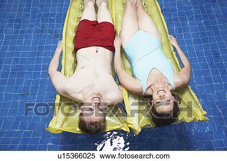 Stock Photography - Portrait of couple lying on a lylo.. Fotosearch