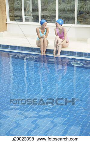 Stock Photo - Two woman by edge of swimming pool.. Fotosearch