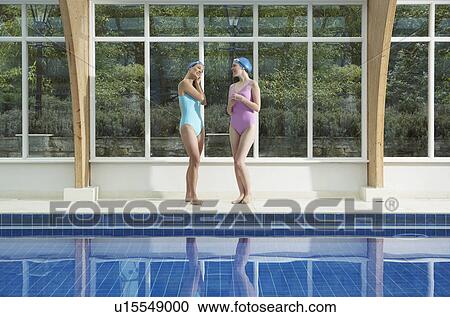 Stock Image - Two woman standing by a pool.. Fotosearch