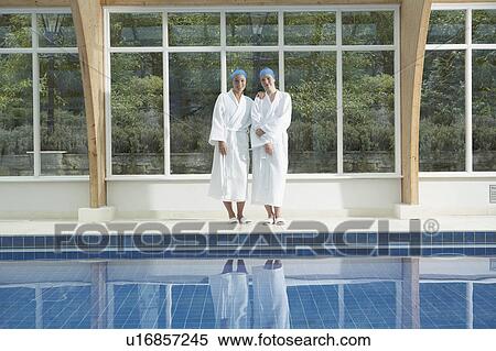 Stock Photography - Two woman standing by a pool.. Fotosearch
