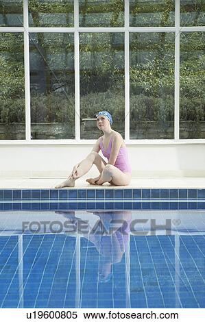 Stock Photography - Woman sitting by swimming pool.. Fotosearch
