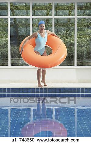 Woman standing with rubber ring by pool. View Large Photo Image Stock Image - Woman standing with rubber ring by pool.. Fotosearch