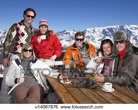 Stock Photograph - Group of friends having drink on terrace. Fotosearch