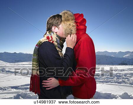 Stock Photo - Man kissing woman on mountain top. Fotosearch