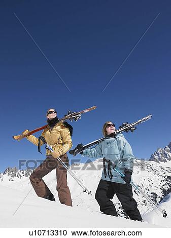 Skiers climbing mountain admiring view View Large Photo Image Stock Image - Skiers climbing mountain admiring view. Fotosearch