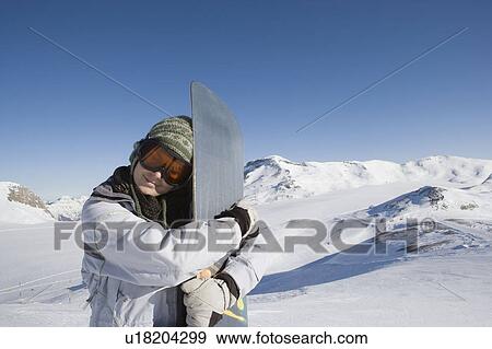 Stock Photo - Snowboarder hugging snowboard. Fotosearch